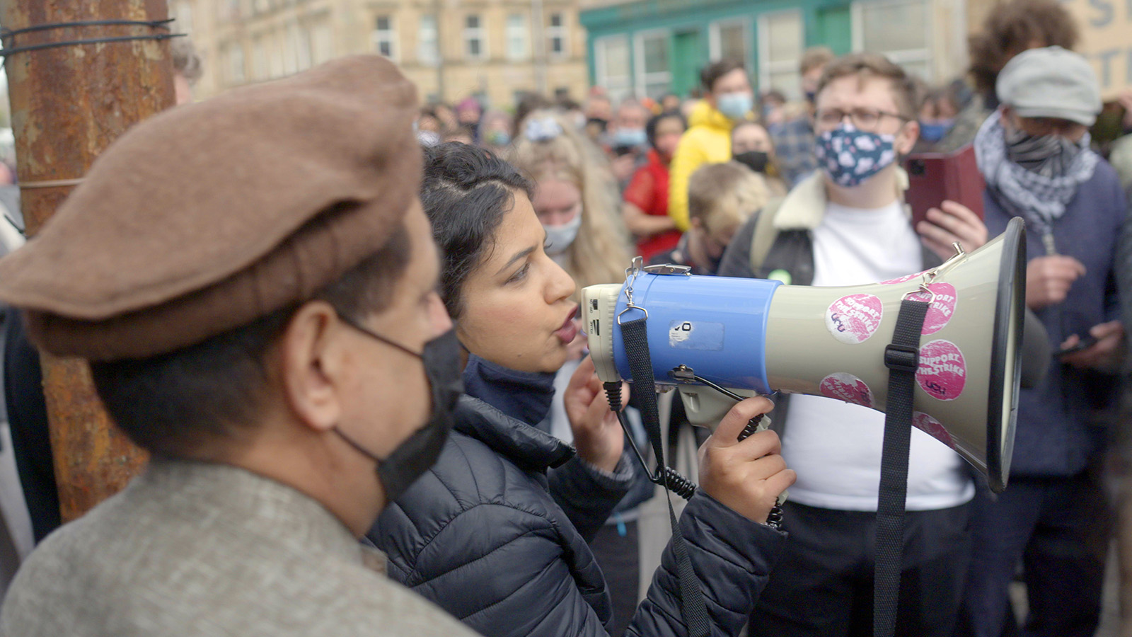 A woman speaks into a megaphone adorned with 