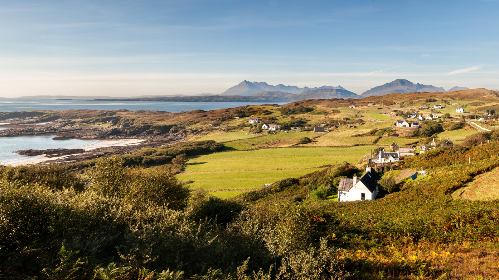 Bannan fields from far away - houses are dotted amongst the landscape next to the seaside