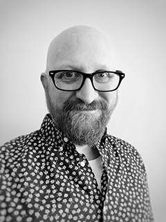 A black and white image of Sambrooke Scott wearing a patterned shirt