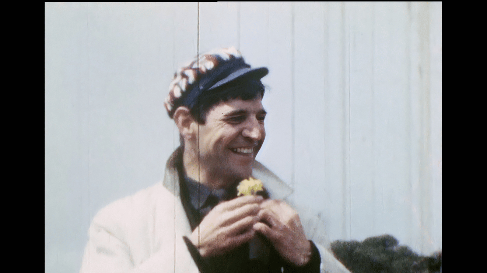 Still from Bill Douglas: My Best Friend. A vintage film image of Bill Douglas wearing a flower cap.