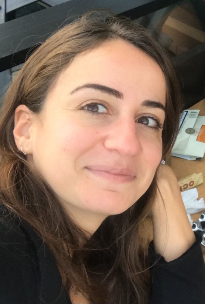 Close up of a woman's face, who sits in a camper van at a table.