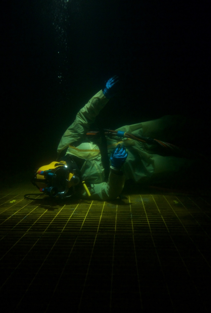 A diver sits on the bottom of the ocean