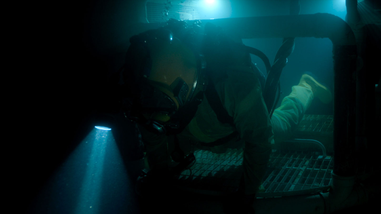A diver climbs through an underwater vessel