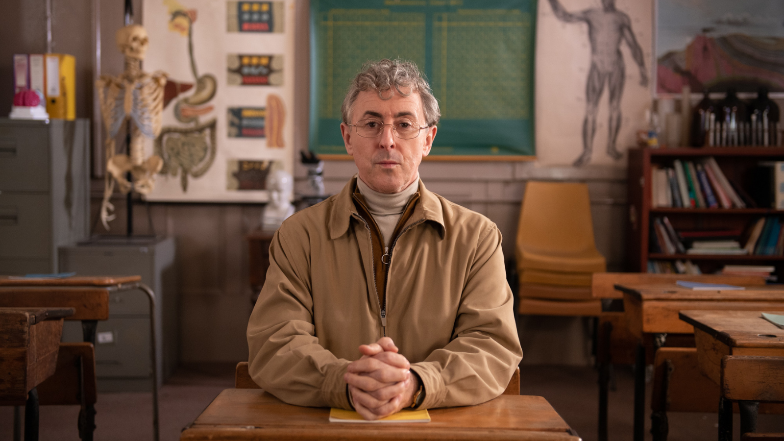 Still from My Old School. Alan Cumming sitting at desk in classroom