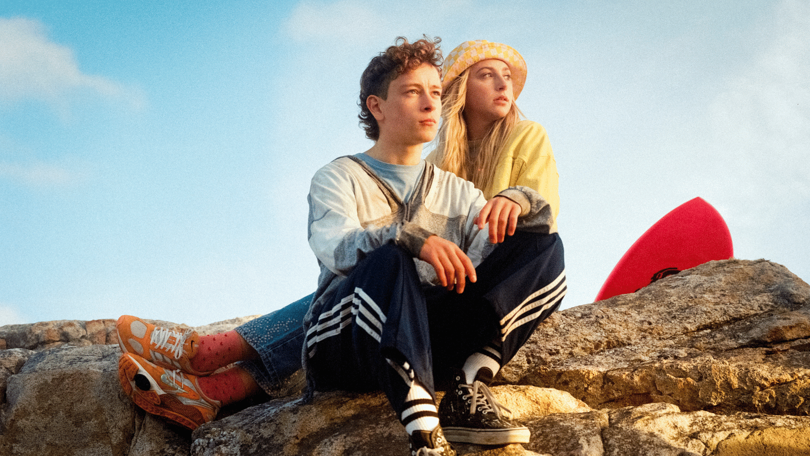 Still from silent Roar. Teenage boy and girl sitting on rock.