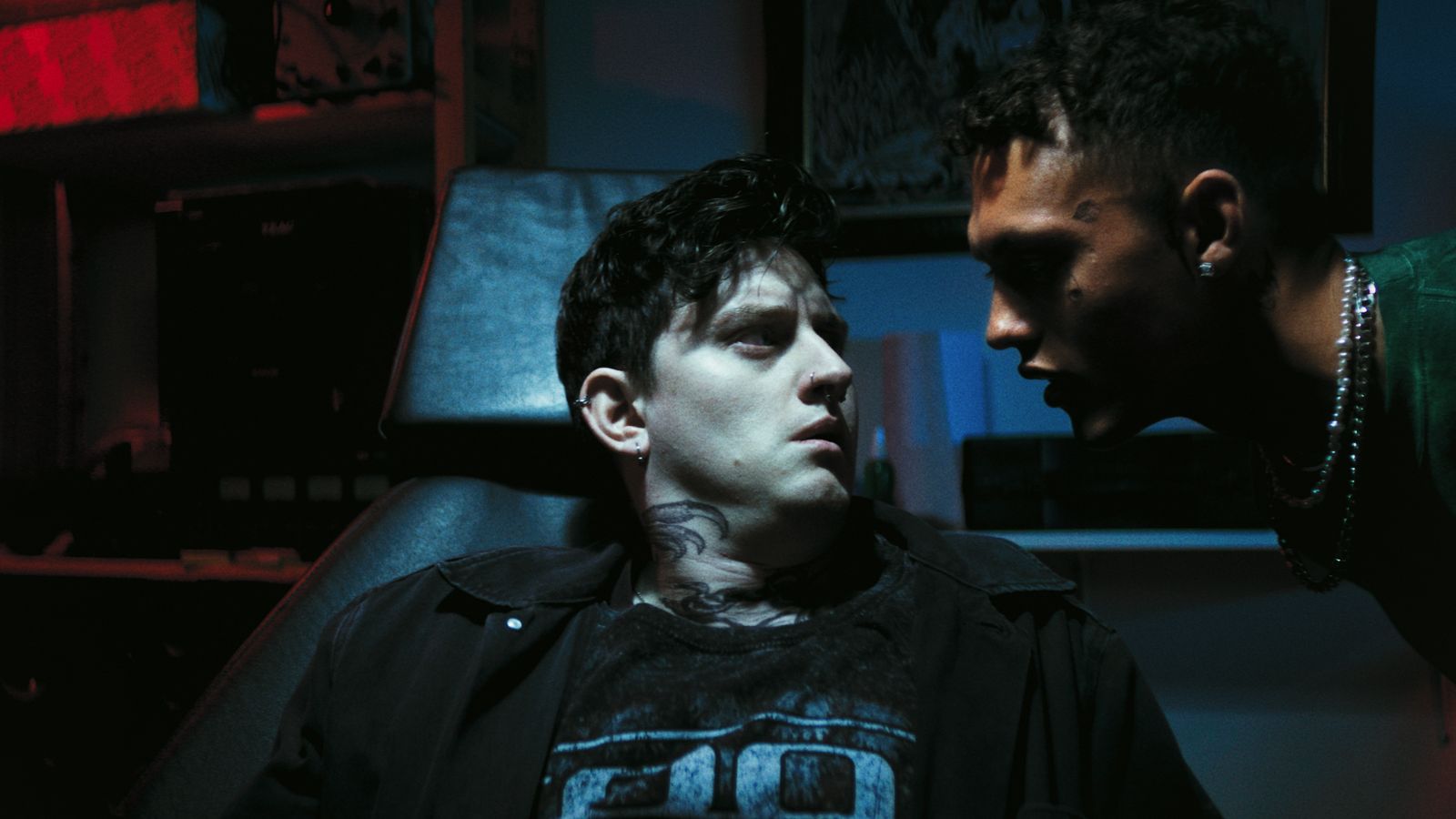 Still from Tummy Monster showing a man lying on a tattoo's chair while another man leans towards him
