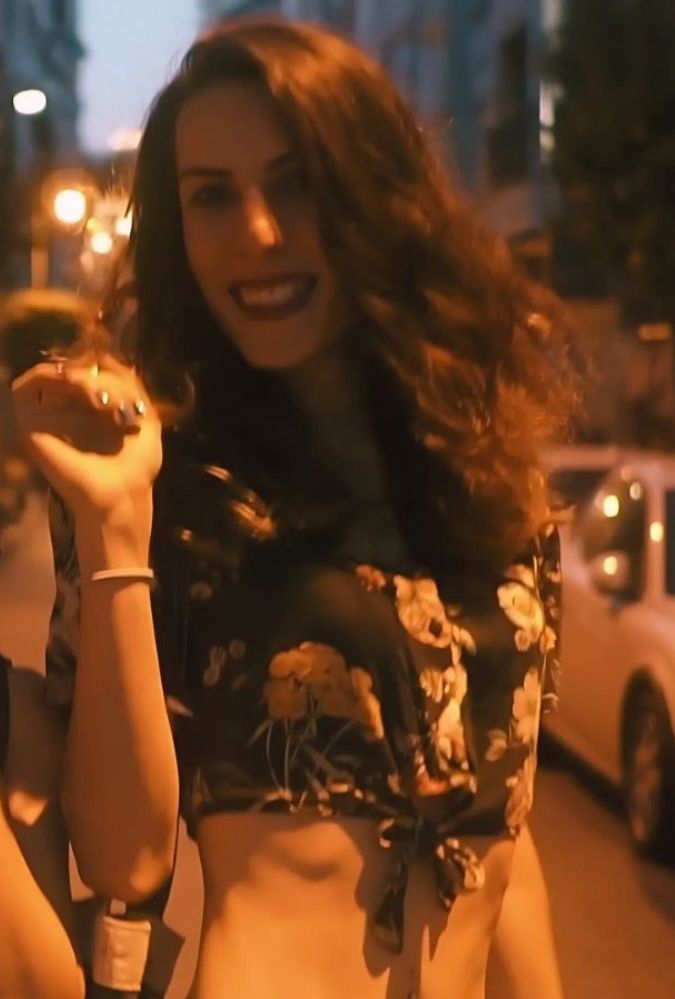 Two people walk down a street in the evening, laughing