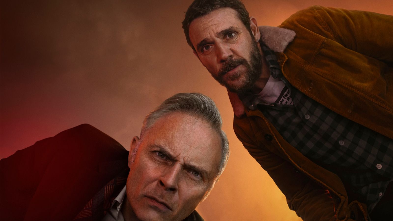 Mark Bonnar and Jamie Sives look down over the camera in a close up shot, with mist in the background