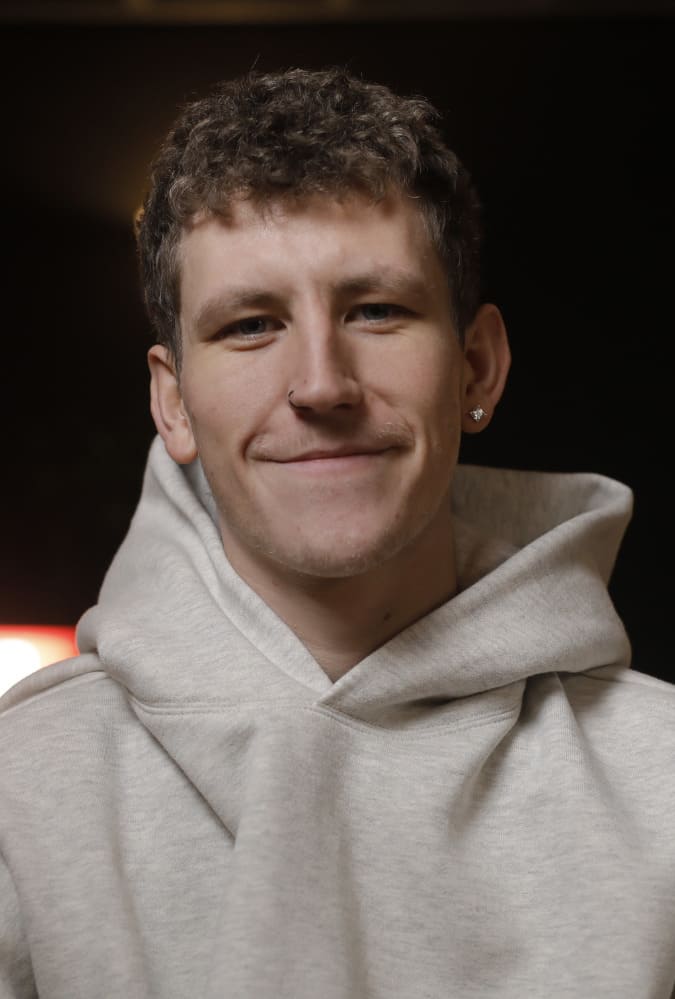 Headshot of Nathan Evans in white hoodie smiling.