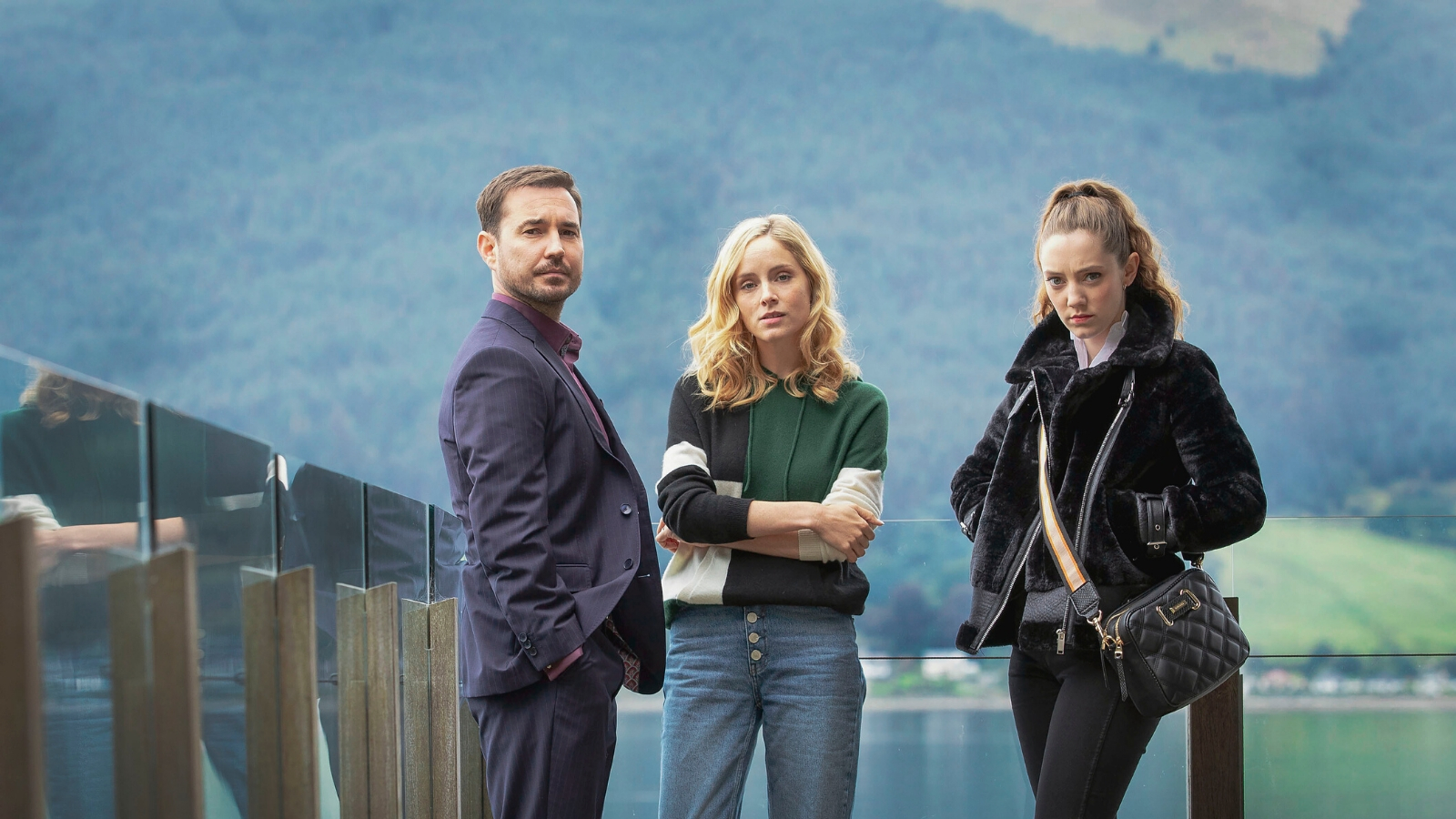 Martin Compston, Sophie Rundle and Mirren Mack stand together with a loch in the background