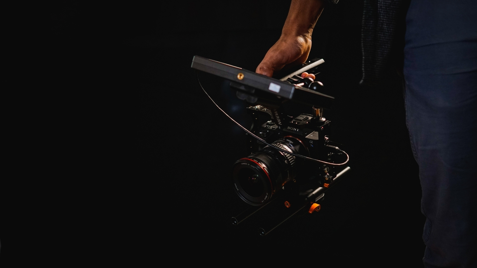 A close up image of a person's hand holding a film camera