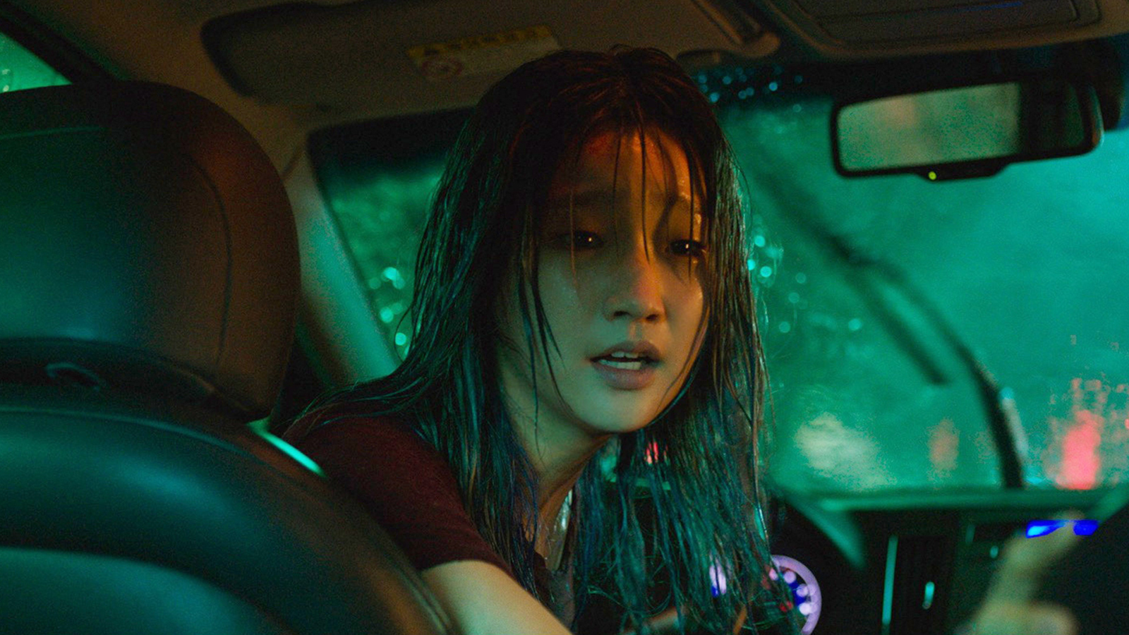 A woman with wet hair in a car. Outside it is raining. This is South Korean actress Park So-dam in a still from Special Delivery