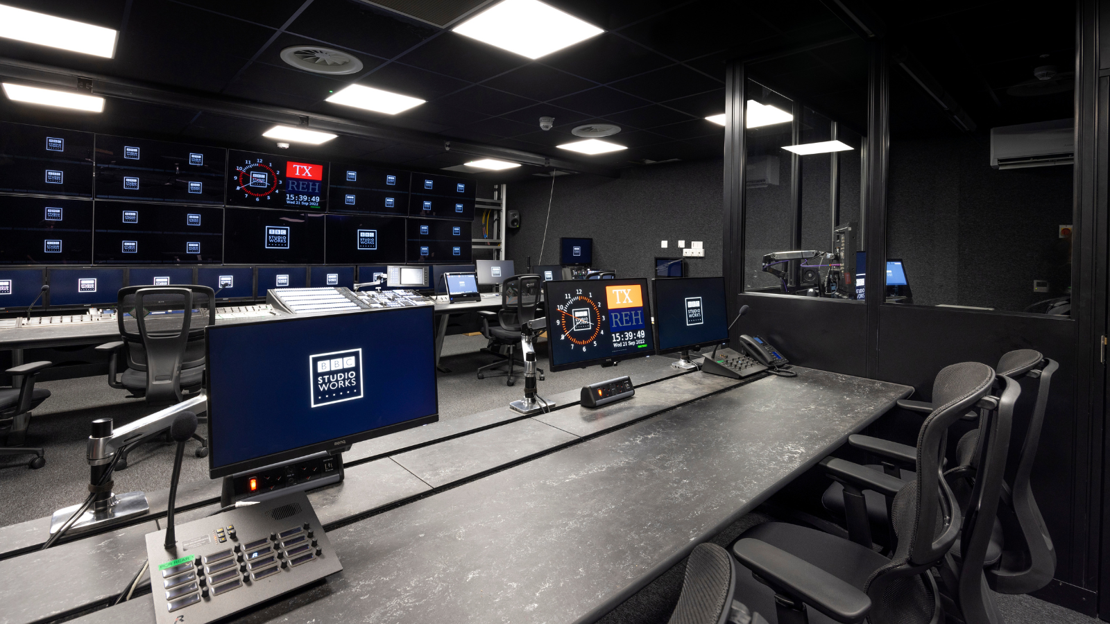 An empty but state-of-the-art looking production office: large screens, chairs, computers and editing equipment