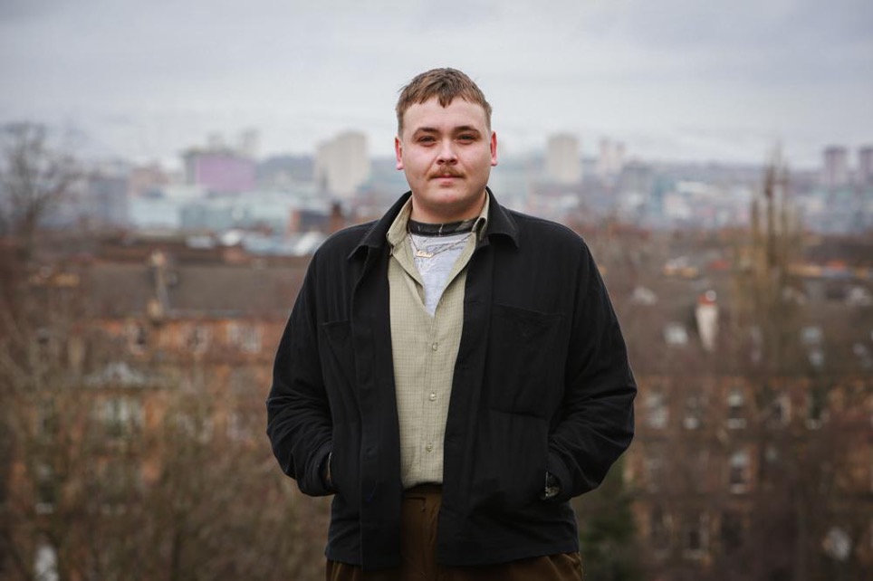 A man with short hair and wearing a black jacket with his hands in the pockets. This is Matthew Cosslett.