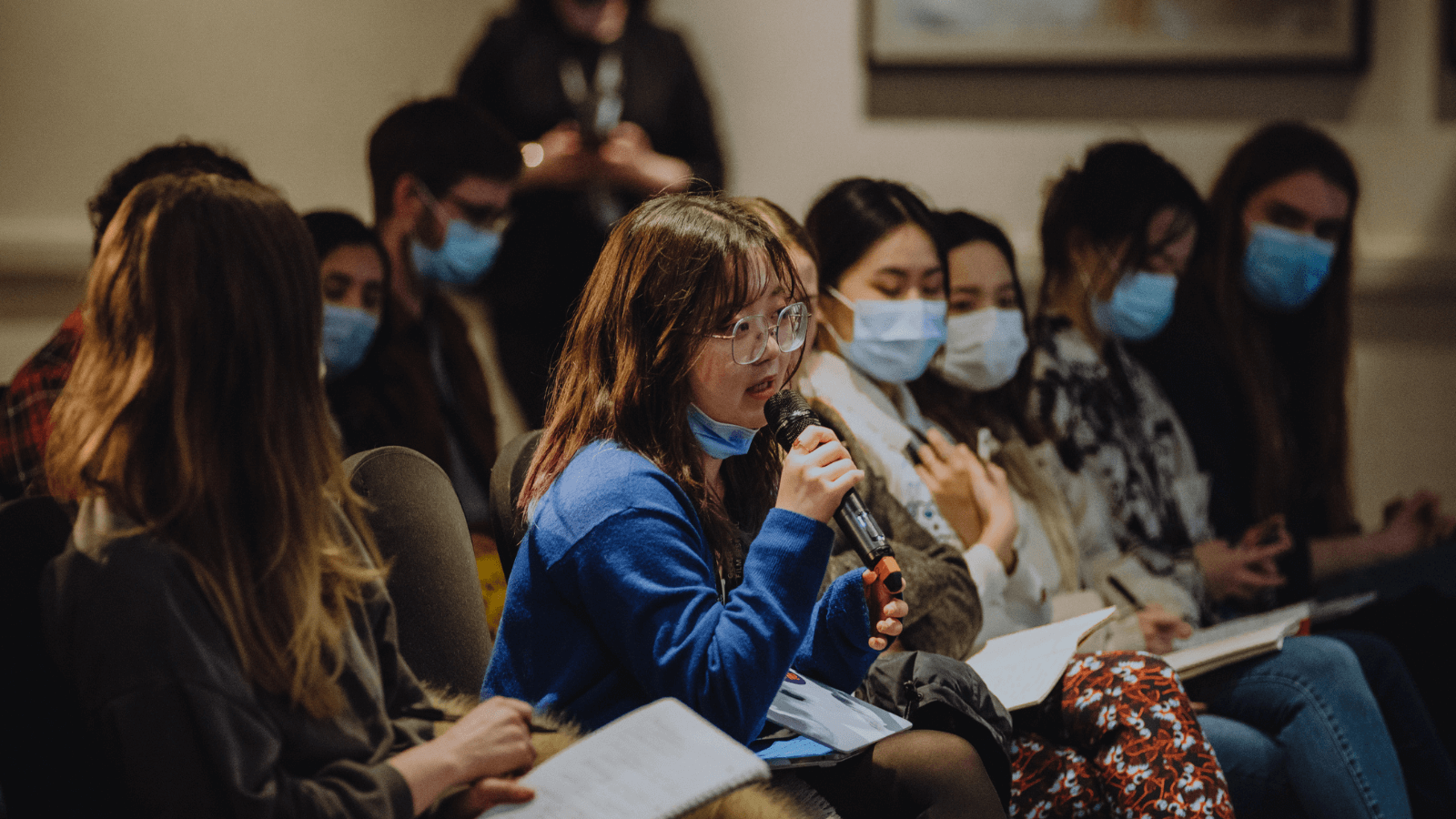 Audience members at a GFF Industry Focus even. Woman has microphone in her hand and is in mid speech.