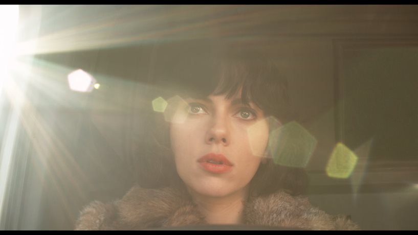 Scarlett Johansson close up in Under the Skin. She has cropped black hair and red lipstick.