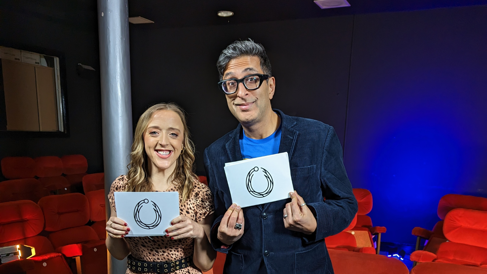 Catriona Logan and Sanjeev Kohli holding white cards with the Torc awards logo on them