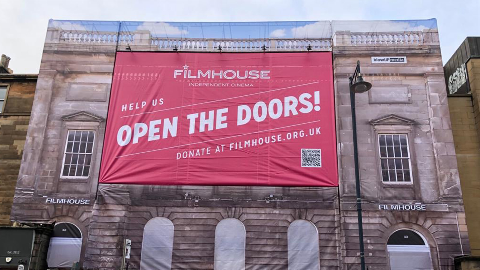 The sign outside the FilmHouse which is a giant red banner with the word Open the Doors emblazoned across it. Image courtesy of Filmhouse (Edinburgh) Ltd