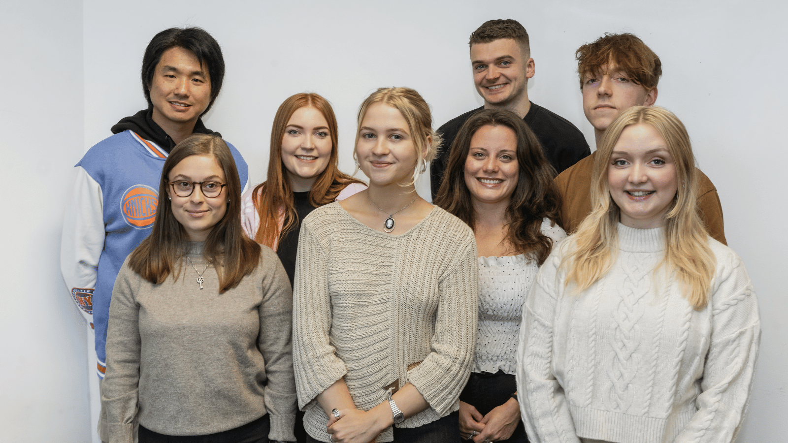 Group shot of Pact Scotland trainees 2023. There are eight people, standing in two rows smiling at the camera.