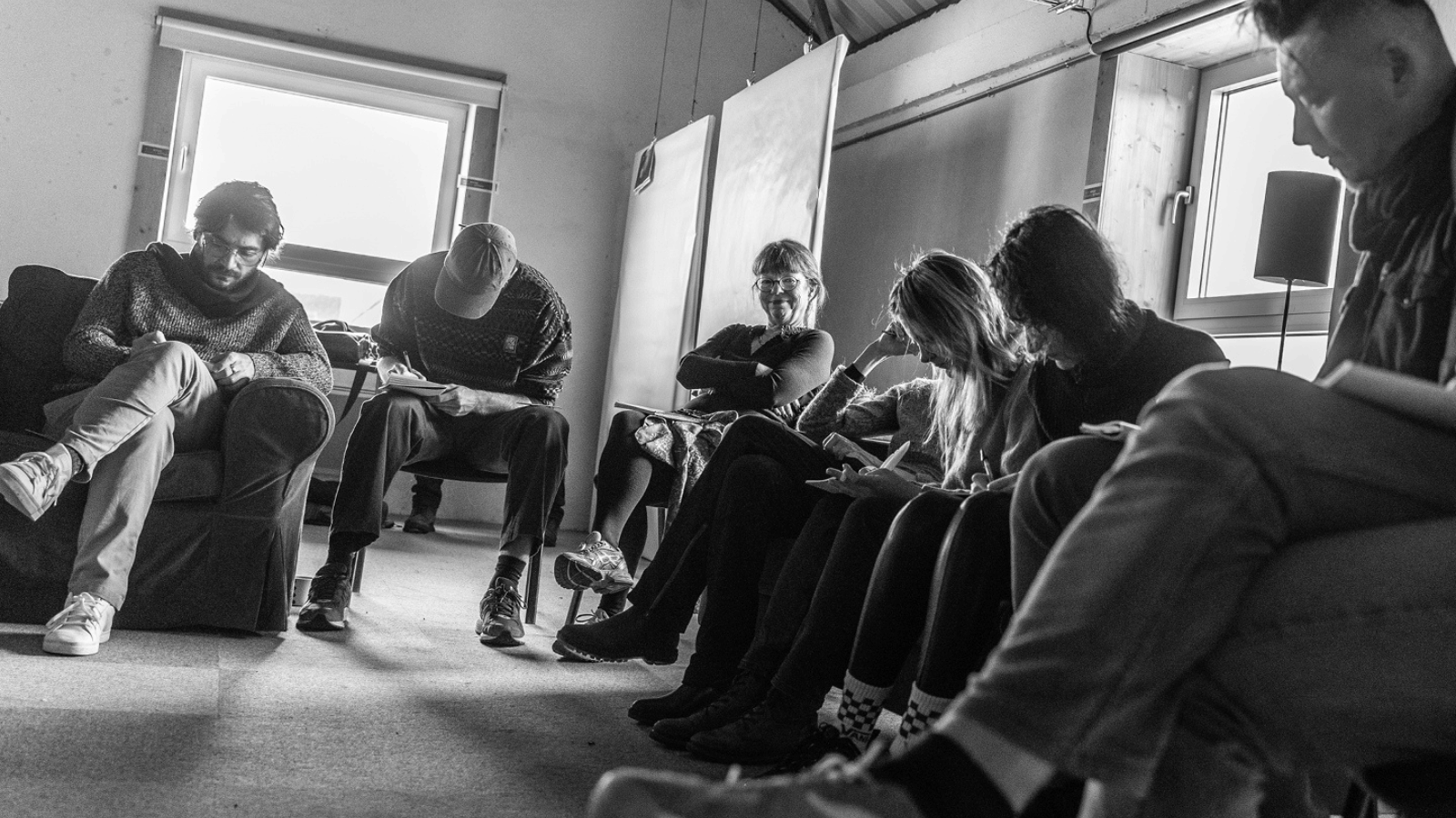 Less is More Residential 2022, credit: Brigitte Bouillot. Black and white image of a group of people sitting in a semi circle on chairs.