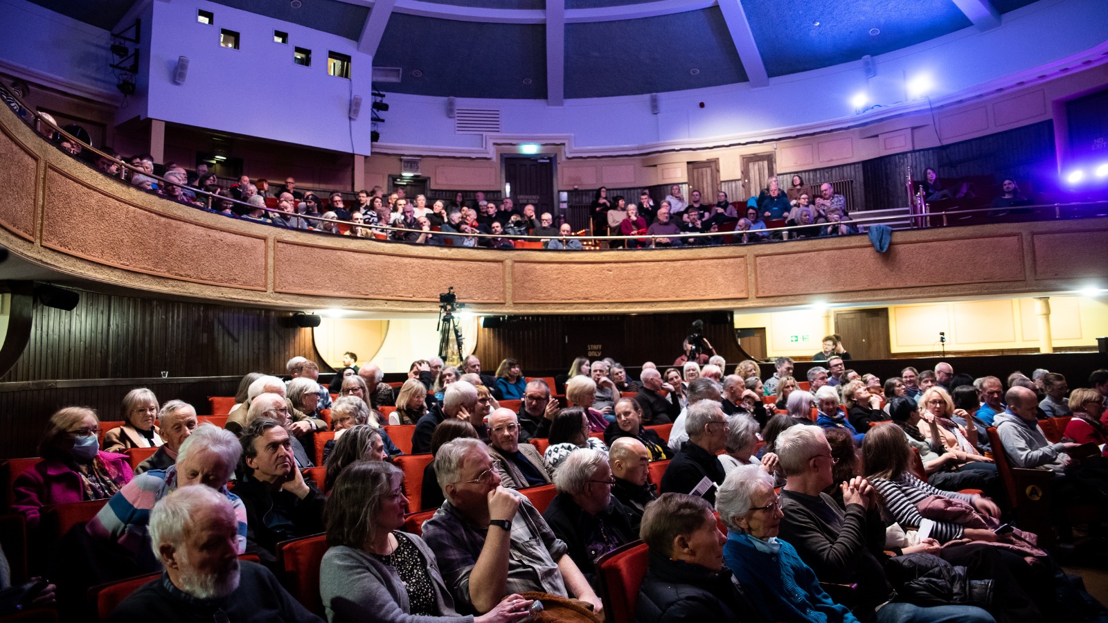 An audience sits in a cinema watching a film screening