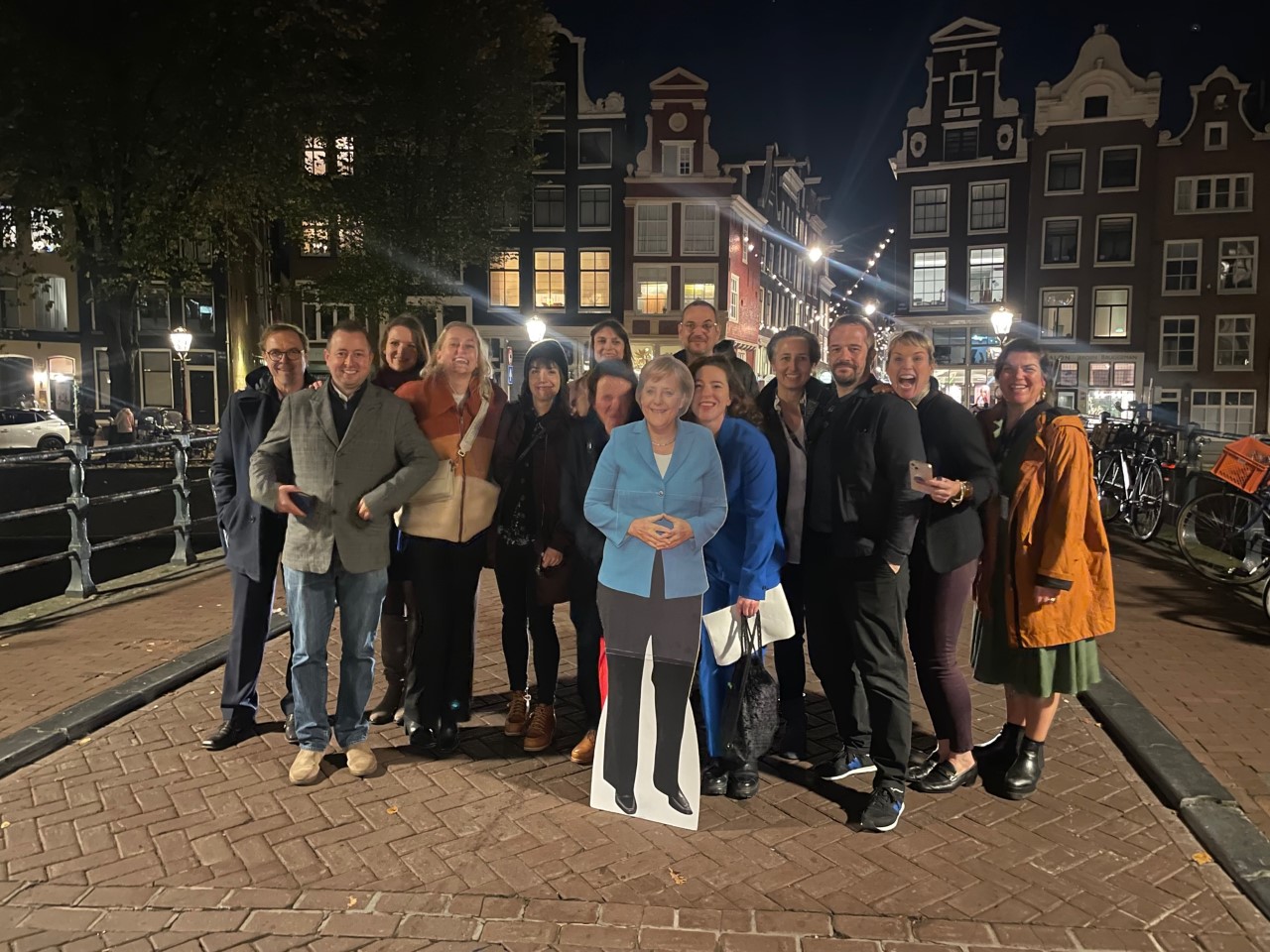 Merkel team at IDFA on bridge with cardboard cutout of Angela Merkel