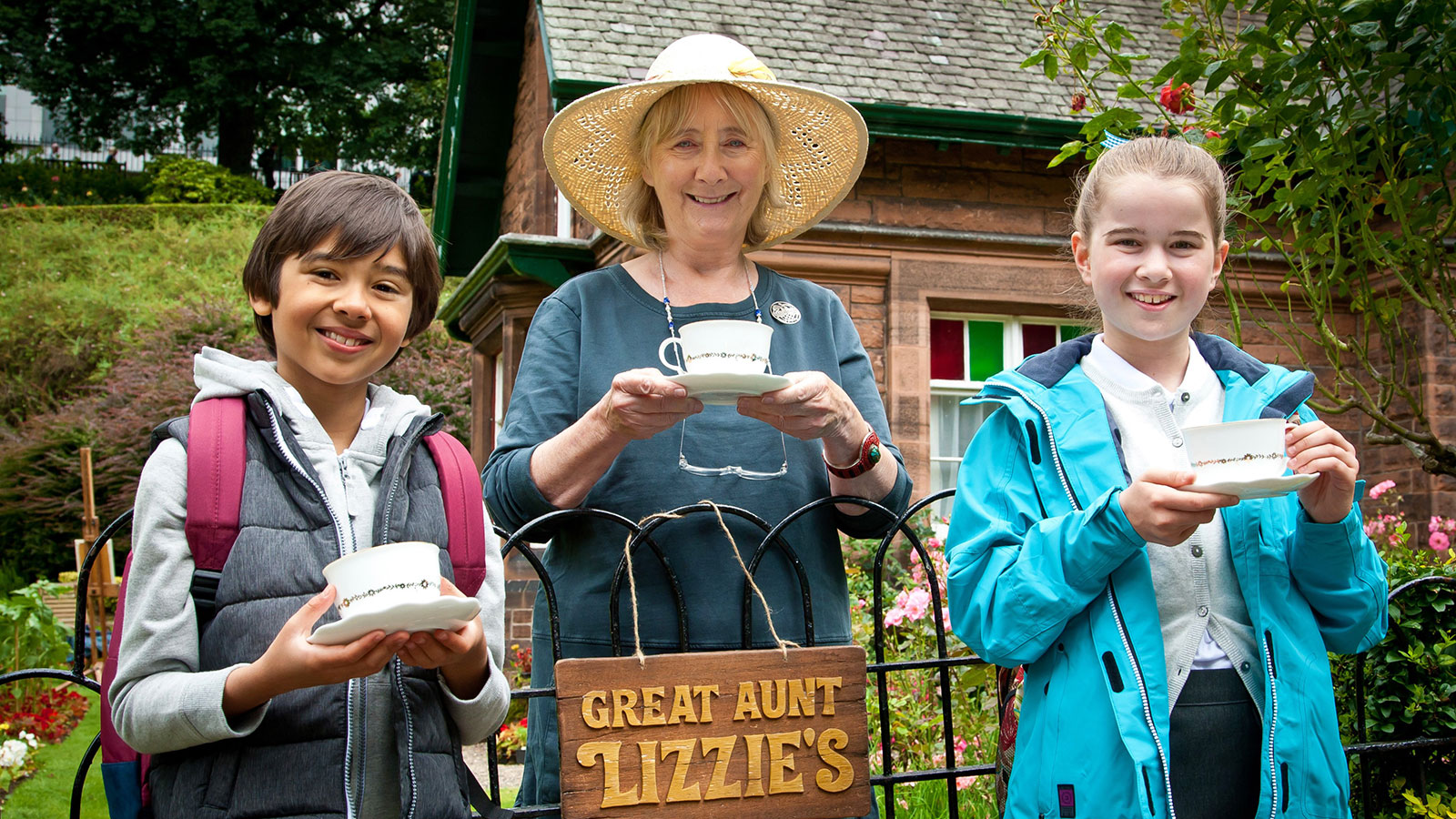 Teacup Travels - showing two children and an older woman holding teacups and smiling