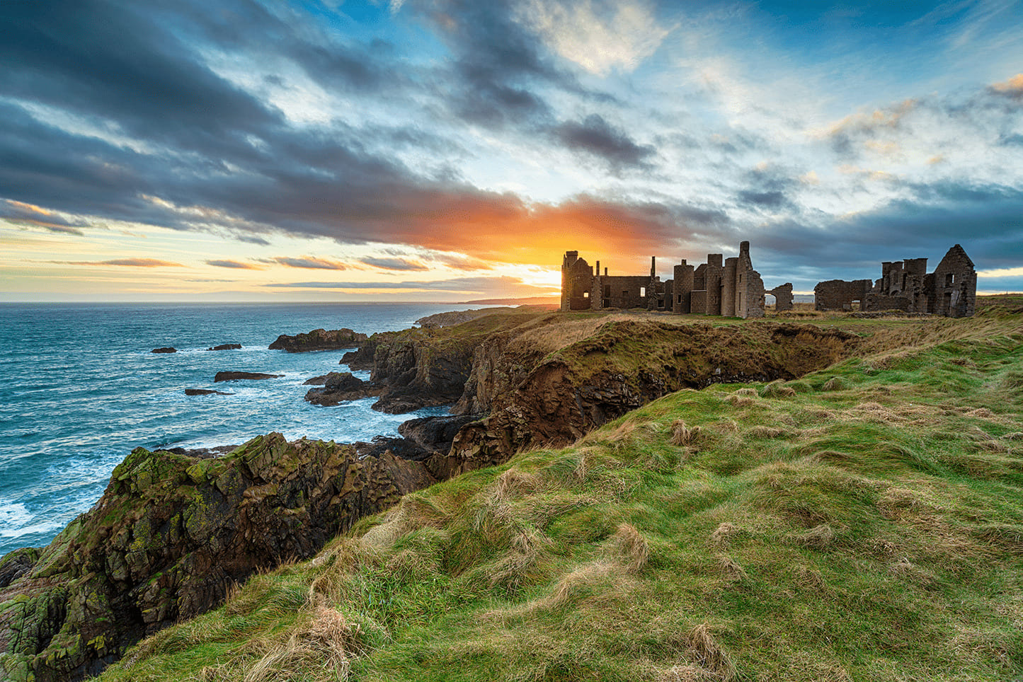 A ruined castle on the edge of the water in Scotland against a bright sky