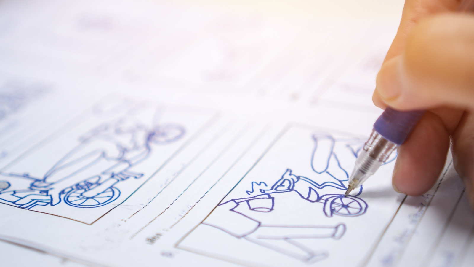 A person's hand draws a cartoon for an animation on a storyboarding sheet