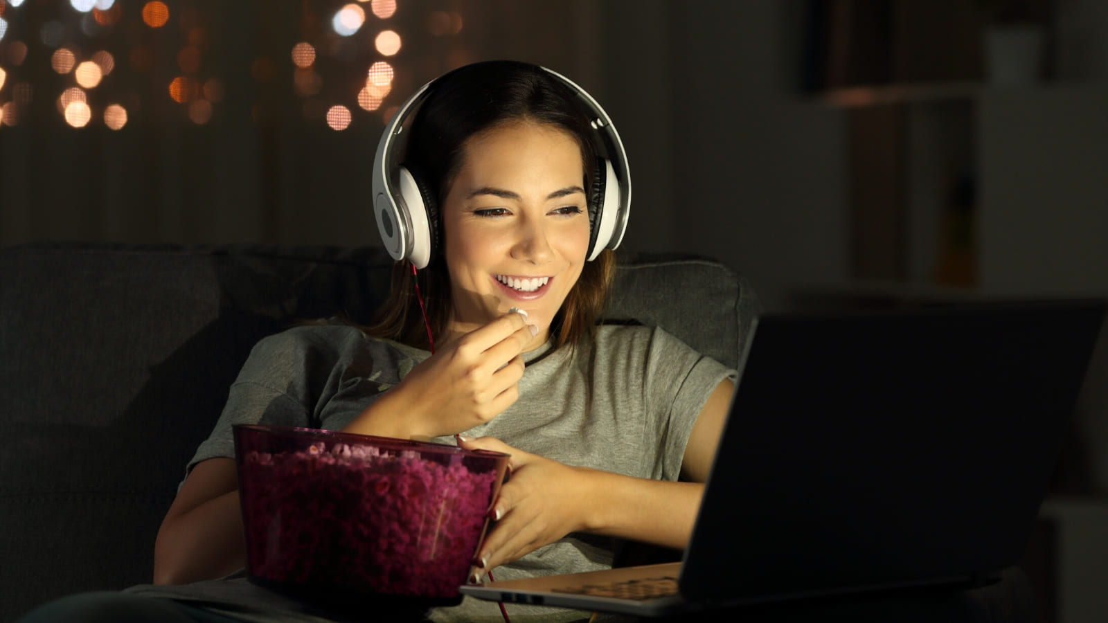 A person sitting in a cosy room with headphones on