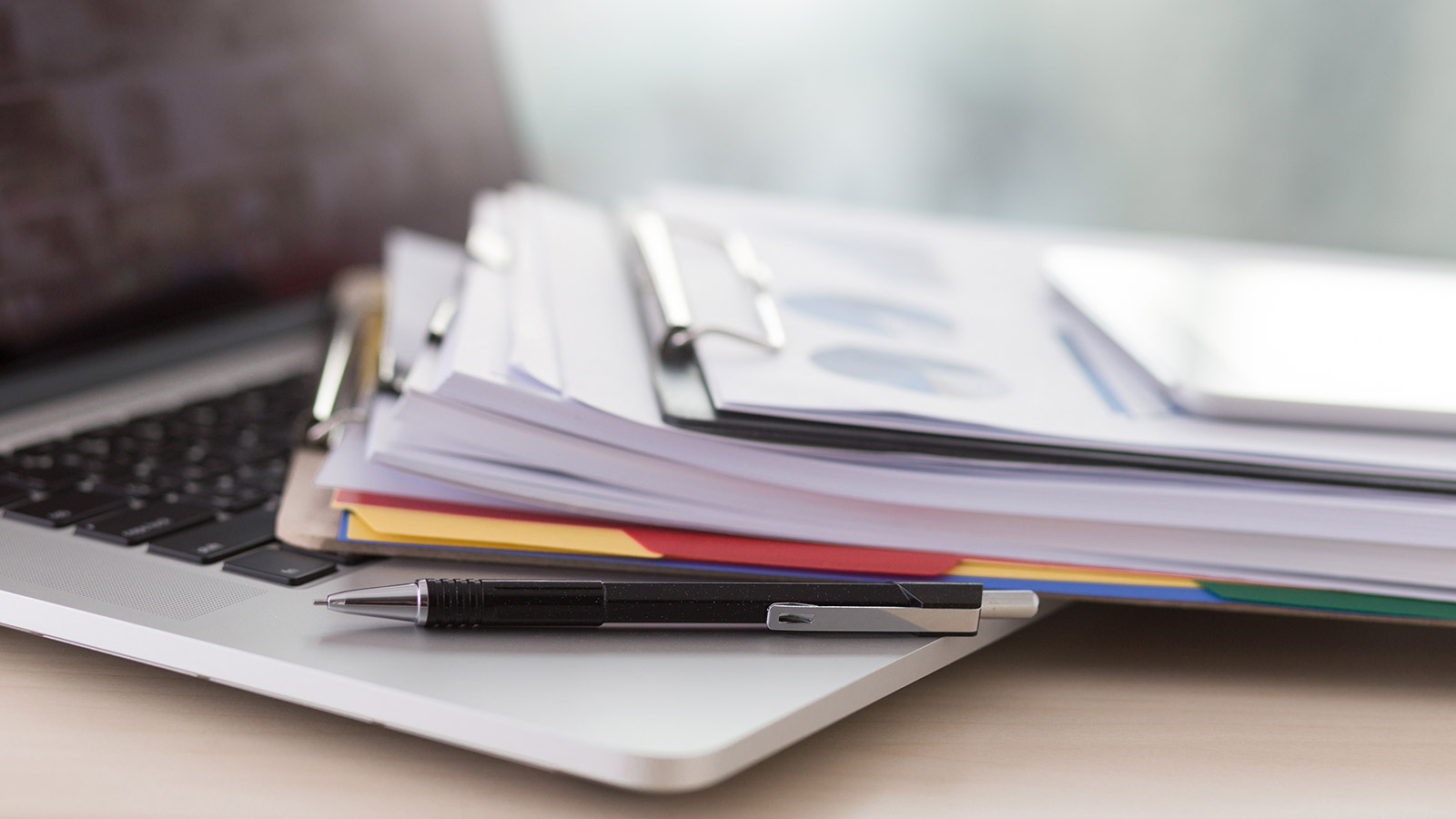 Documents sitting on top of a laptop