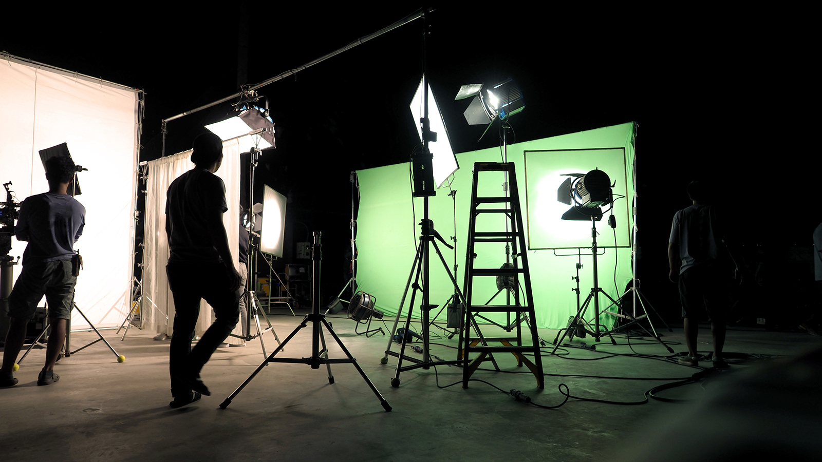 Photo of a film set with cameras and a green screen