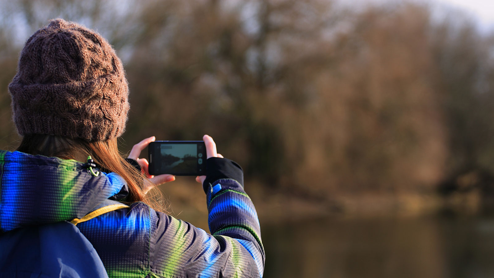 Girl with camera phone outdoors