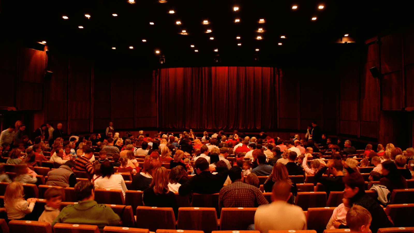 An audience in red seats in a cinema